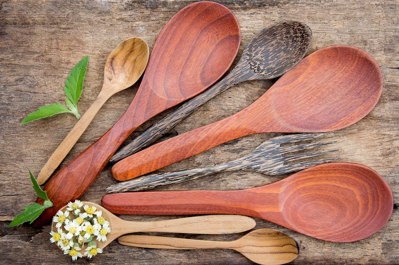 Services Top view of rustic wooden kitchen utensils and small flowers on a textured table.